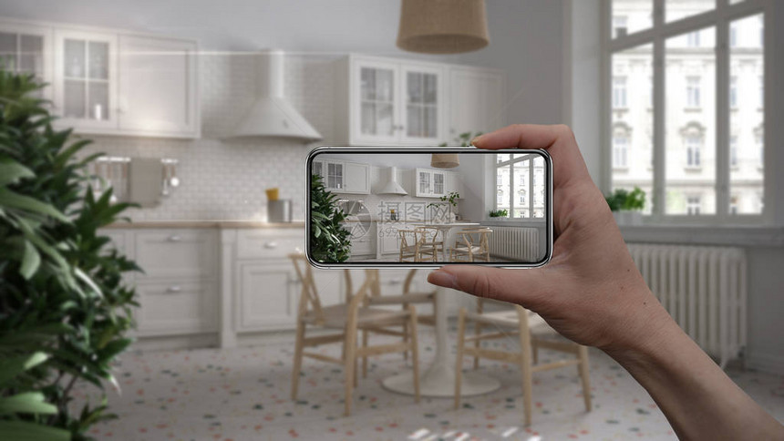 手持智能手机AR应用模拟真实家居中的家具和室内设计产品建筑师设计师概念模糊背景带厨图片