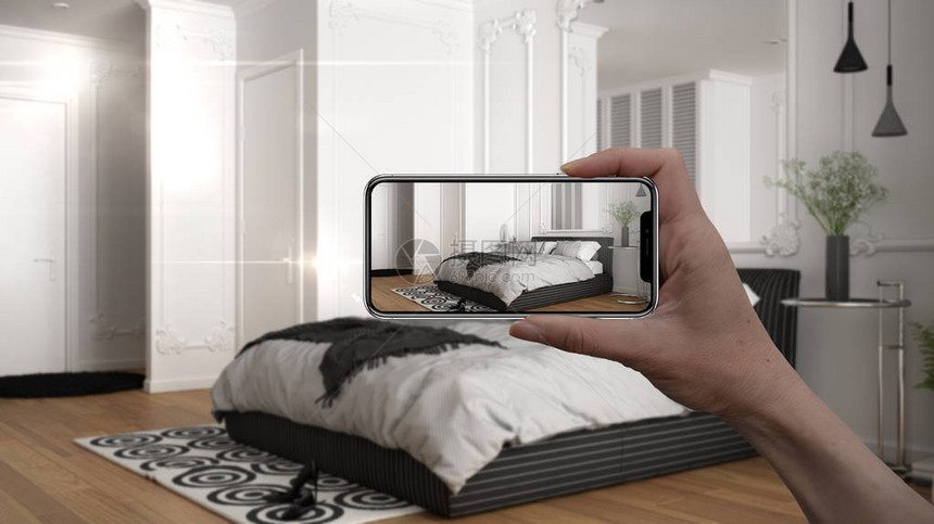 手持智能手机AR应用模拟真实家居中的家具和室内设计产品建筑师设计师概念模糊背景带床和装图片