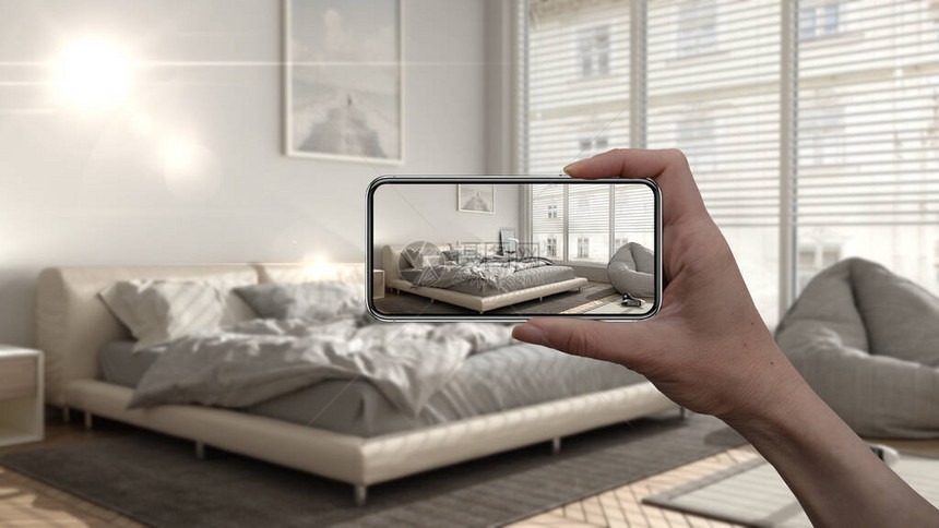 手持智能手机AR应用模拟真实家居中的家具和室内设计产品建筑师设计师概念模糊背景带床和装图片