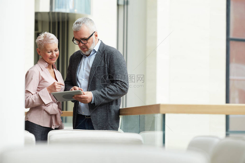 两位高级商务人士站在阳台上讨论工作复图片
