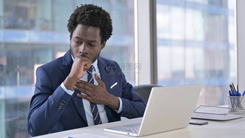 使用笔记本电脑时咳嗽的非裔美图片