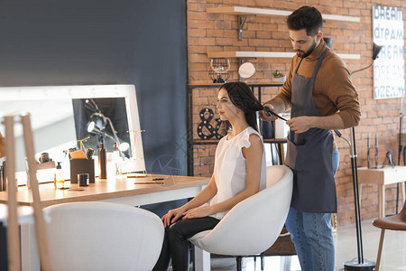 美发师在沙龙与客户一起工作图片