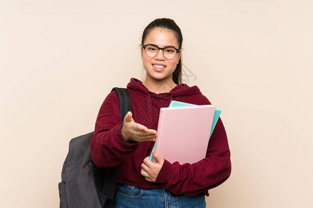 年轻的亚洲女学生在交易后与孤立的背景握手图片