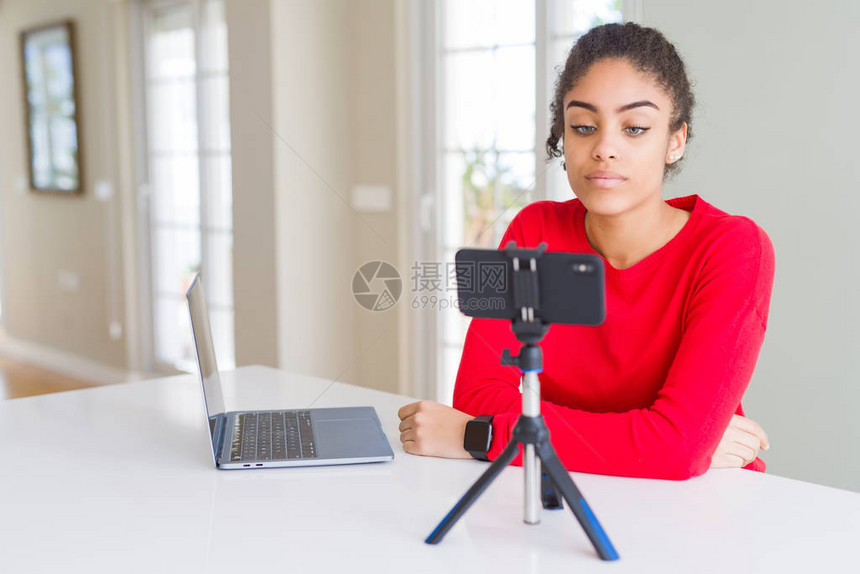 使用智能手机摄像头进行视频通话的年轻非裔美国妇女面部表现严肃图片