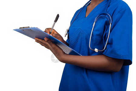 身着蓝色上衣的女护士或医生在剪贴板上持有和写作以图片