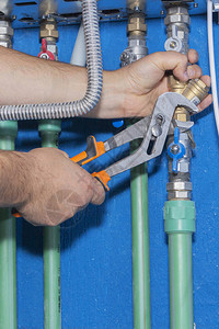 水管工使用活动扳手连接到管道燃气锅炉图片