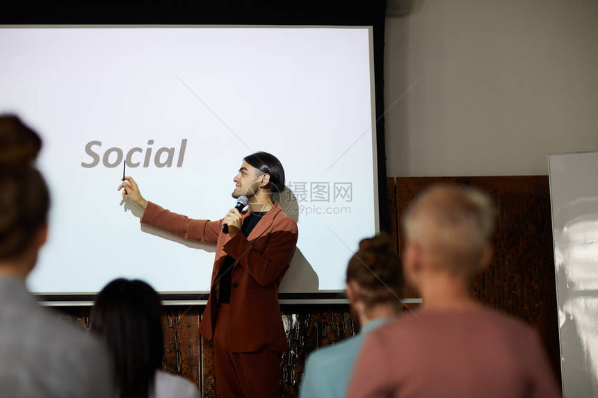 中东部青年商人在会议影印空间上发表关于社交媒体营销演讲的侧面肖像图片