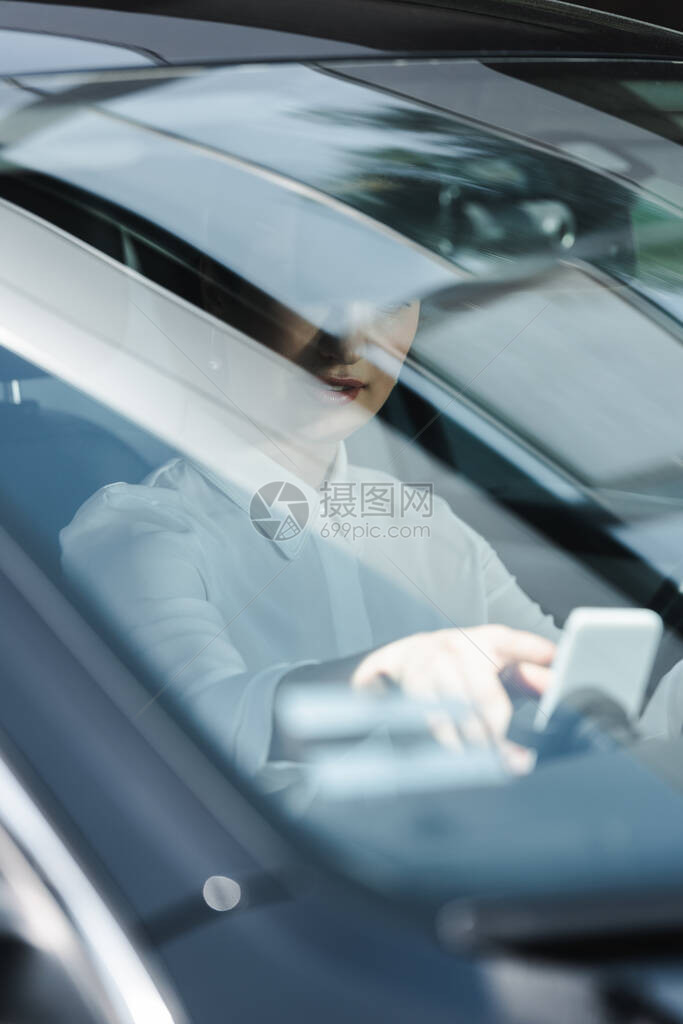 以智能手机作为汽车驾驶员座椅的商业妇女有图片