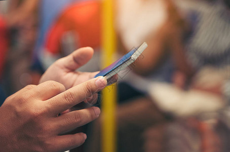 夜间在城市火车上使用智能手机的男手特写图像搜索或社交网络概念潮人向图片