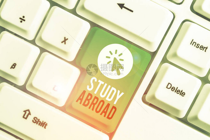显示出国留学的书写笔记在外国寻求教育机会的商业理念白色pc键盘与白色背景图片
