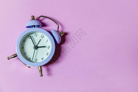 简单的最小设计敲响双钟复古经典闹钟隔离在紫罗兰色背景图片