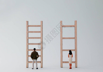 微型男人和女人站在不同的梯子前别歧图片