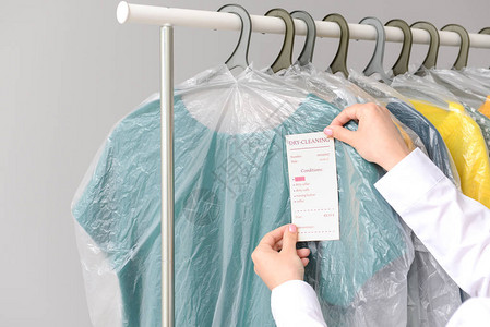 干洗店工人在衣服上贴标签背景图片