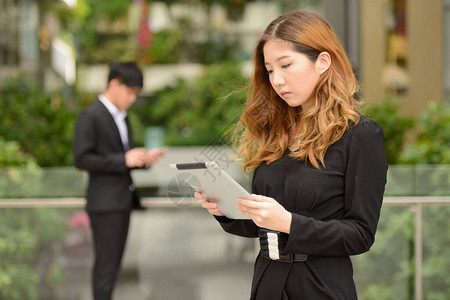 年轻亚洲商人和年轻亚洲女商人在城市户图片