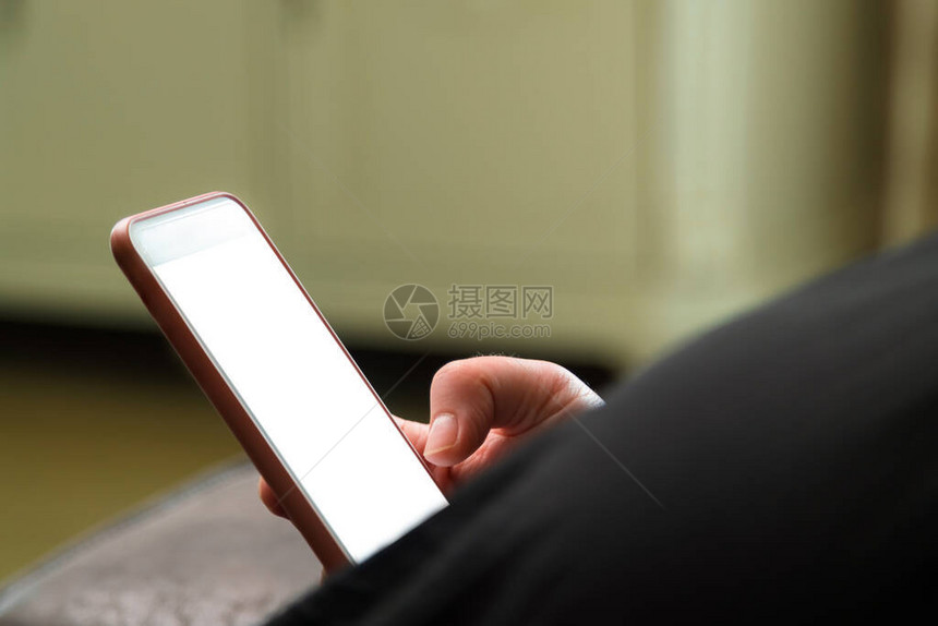妇女在家里的智能手机上读近距离新闻图片
