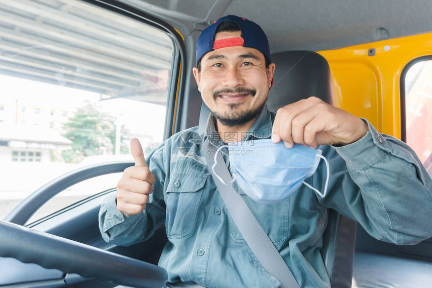 特写照片亚洲卡车司机在车前开心地微笑他戴着防尘口罩图片