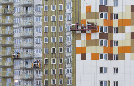 住宅高层公寓楼的立面装饰工人们完成门面的装饰建筑工人在墙上图片