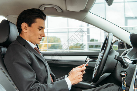 商人在无人驾驶汽车中使用智能手图片