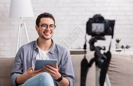 个人博客和数码相机录音手持平板电脑的笑嬉马的家伙正在拍图片