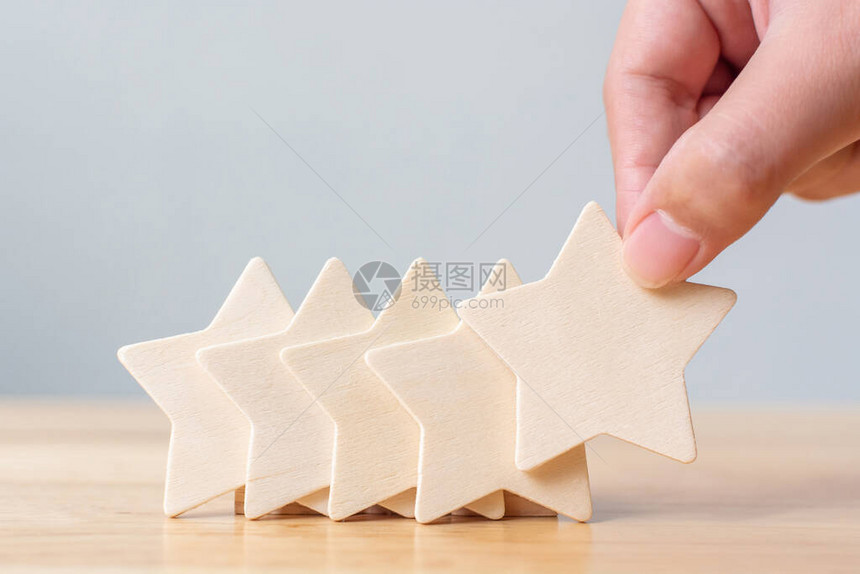 手把木制五星形状放在桌面上最佳商业服务对客户经验的评级概念是最图片