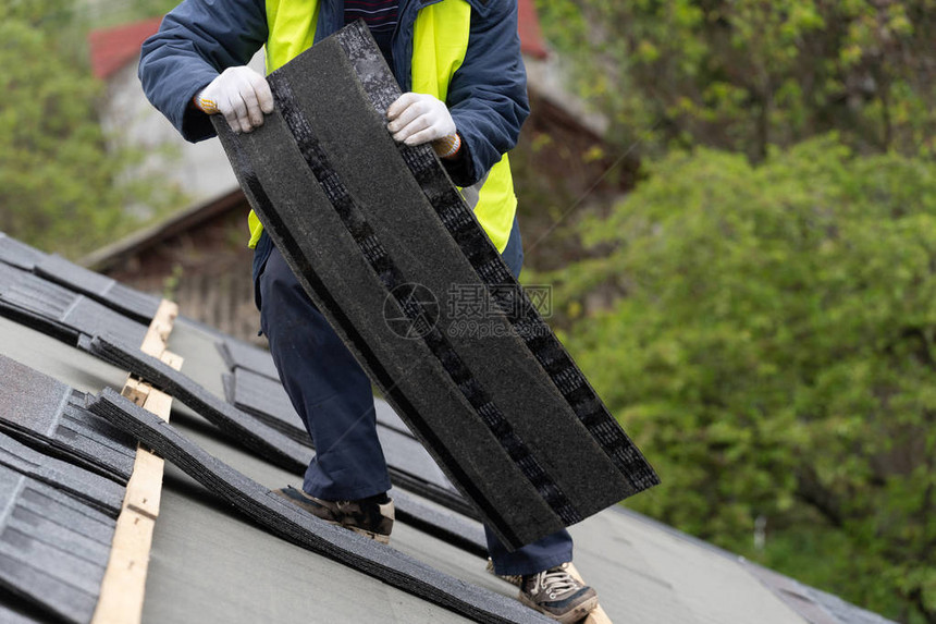 在建筑房屋顶上安装沥青或沥青瓦的特殊防护工作服中无法辨认的图片