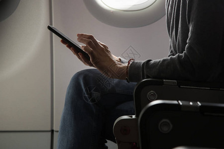 女人独自坐在飞机座位上看手机图片