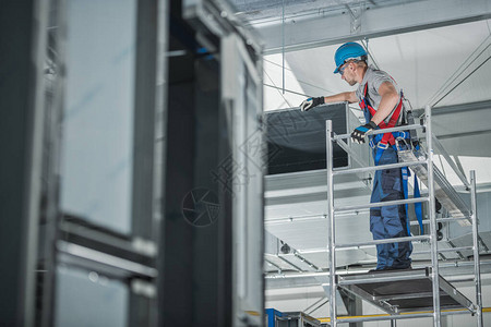 建筑工人检查新安装的大型商业大楼天花板空气通风损耗情图片