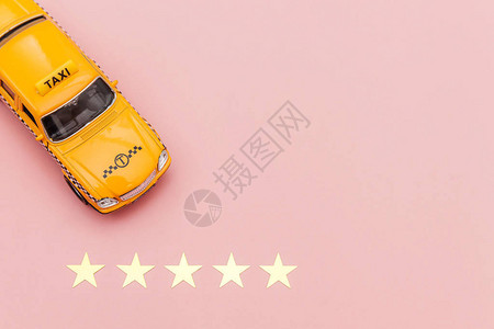 黄色玩具车出租车和5星评级隔离在粉红色背景出租车服务的智能手机应用图片