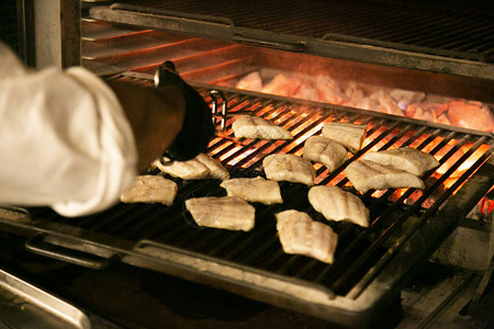 厨师在烤肉上煮鱼图片