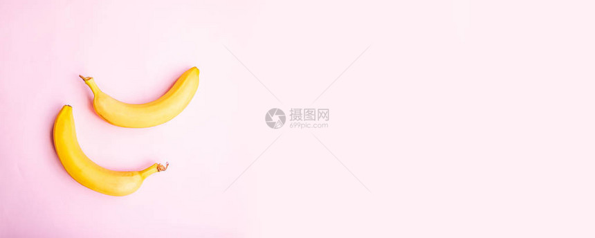 粉红色背景上甜两个香蕉的平面组合图片