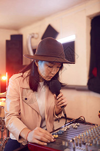 年轻亚洲女在录音室和麦克风复制空间的歌唱中图片
