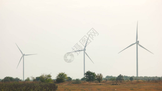 农业领域的风力发电厂组工作在天空背景的三个风力涡轮机生产清洁能图片
