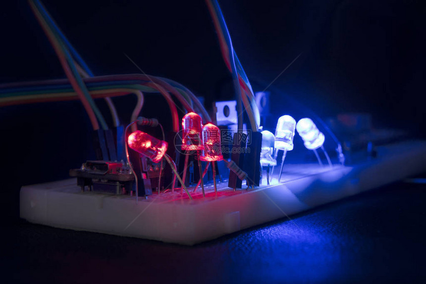 面包板arduino纳米原型板晶体管电阻器LED红色和蓝色在黑色皮肤上图片