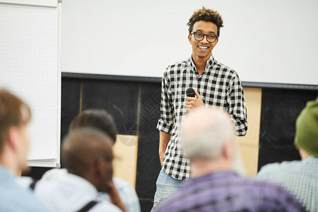 积极成功的年轻非洲裔美国企业家戴着眼镜站在观众面前图片