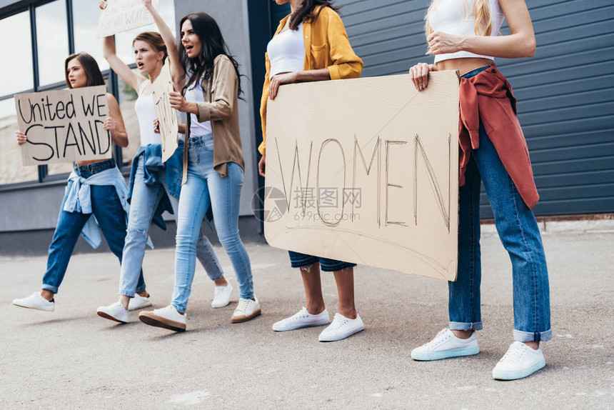 女权主义者在街上举着标语牌的剪影图片