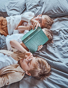 男孩们在软蓝床上的轻木房里社交和玩耍图片
