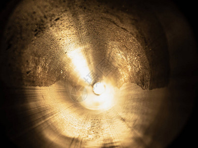 阳光透过的长钢管通过管子的抽象圆形视图片