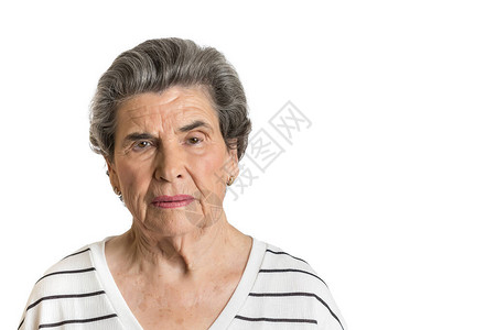 穿着随意衬衫的年长妇女对白色背景隔绝的照相机进行严图片