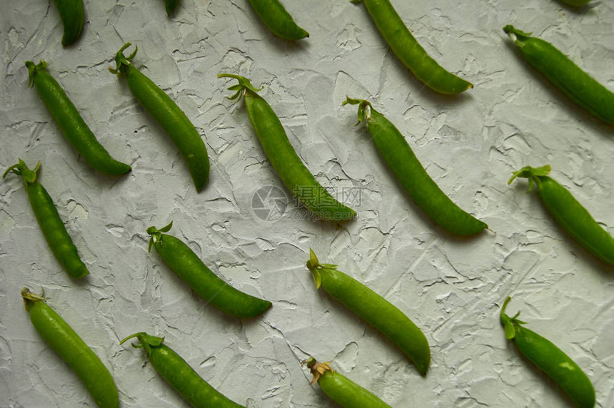 许多绿色豌豆荚在被制造的表面上图片
