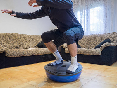 运动员在家里的波苏球上做力气和平衡练习图片