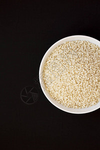 黑色表面的白碗里的有机阿波里奥水稻图片