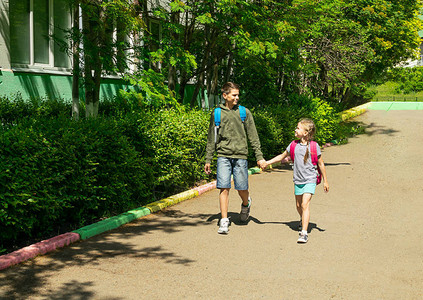 一个男孩和一个女孩的兄弟姐妹带着书包去上学水平框架选择焦点复制空图片