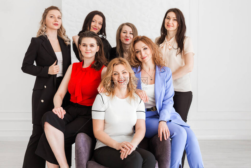 快乐的女工作团队员工组看着在工作室摆姿势的相机图片