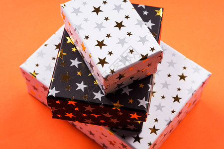 装满金星和橙色背景的礼品盒图片