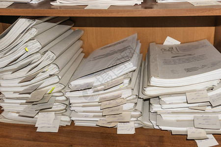 堆积在档案中的纸质文件档案室货架上的文件衣柜里的办公室架图片