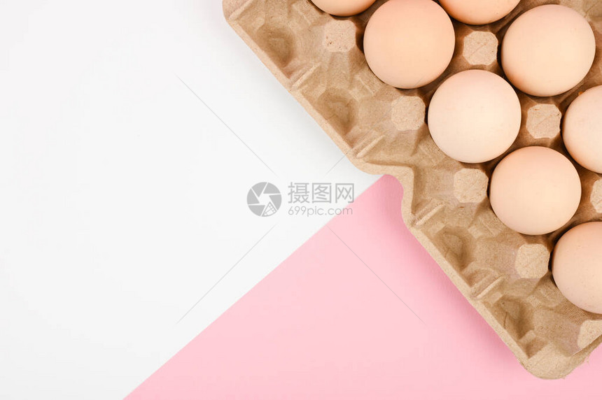 白色和粉红色背景上的一盘鸡蛋带睾丸的生态托盘简约趋势图片