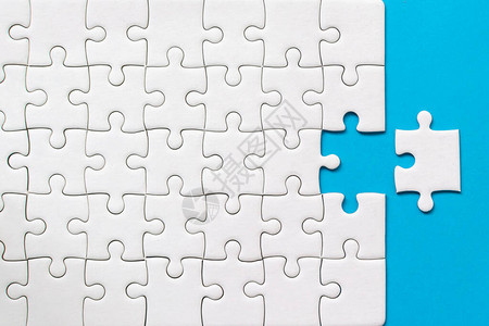 蓝背景的白拼图游戏团队业务成功伙伴关系或团队合图片