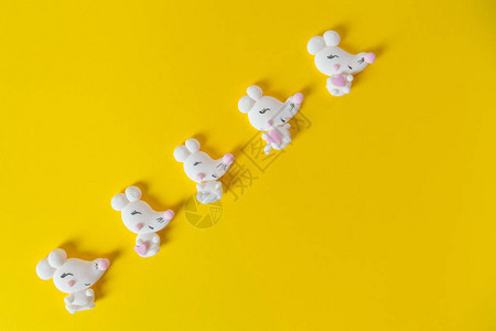 黄色背景上的白色老鼠或老鼠形状的棉花糖图片