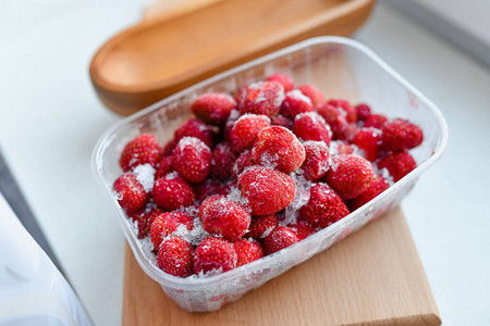 塑料冷冻草莓在冰箱的塑料容器中冷冻草图片