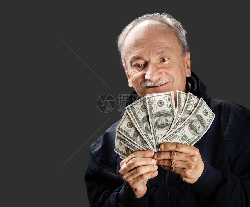 高级绅士拿着一叠钱一个兴奋的老人的画像拿着美元钞票图片